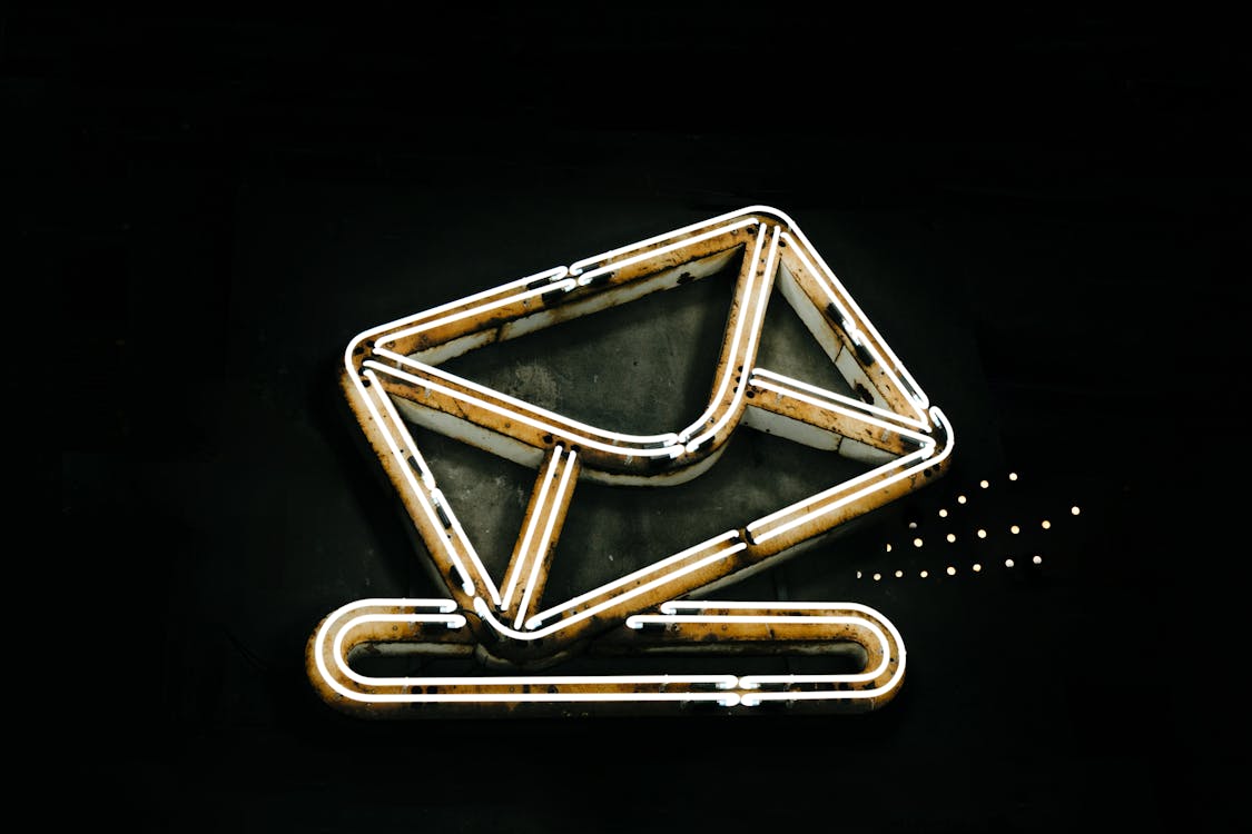 Neon envelope icon glowing in a dark setting representing email marketing