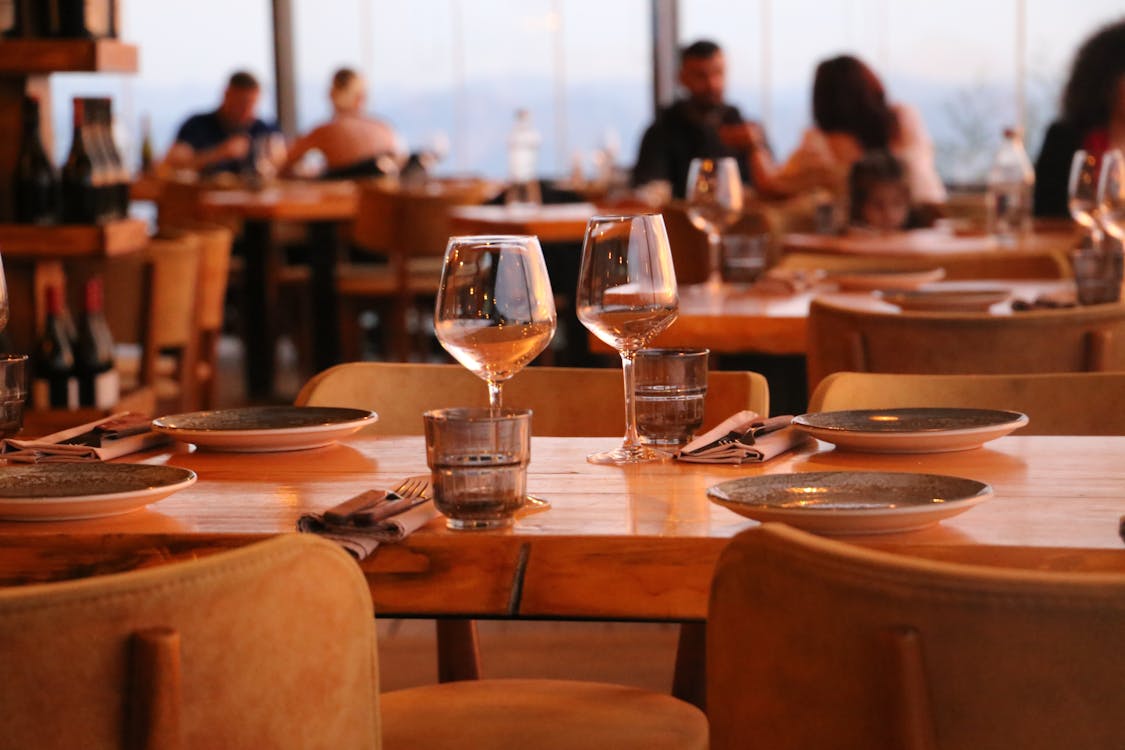 Warmly lit restaurant table set with glassware and plates ready for dining