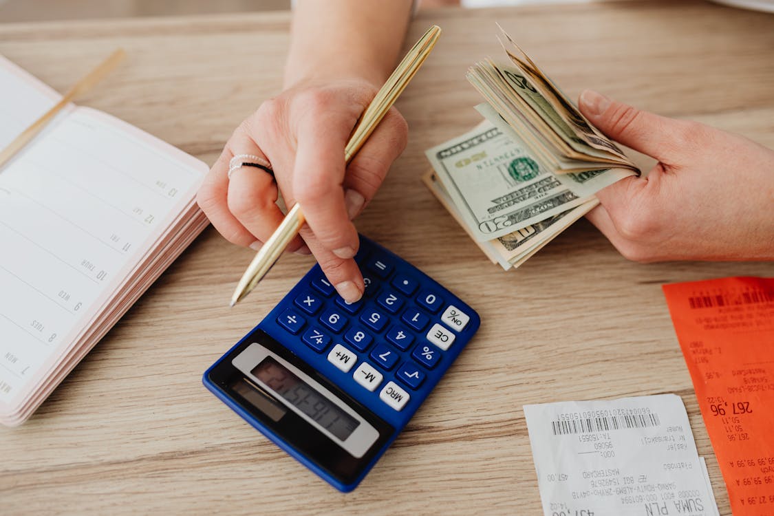 Hands handling cash and calculator for business budget planning