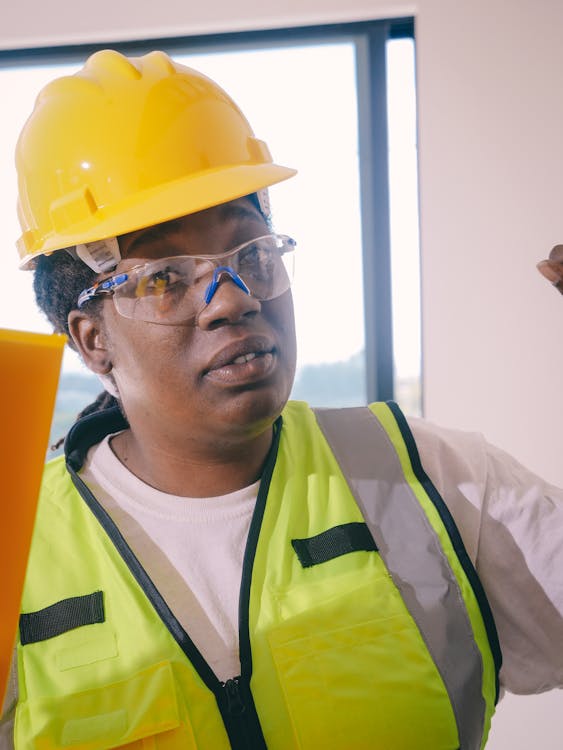 Professional engineer wearing safety gear and a hardhat at a construction site