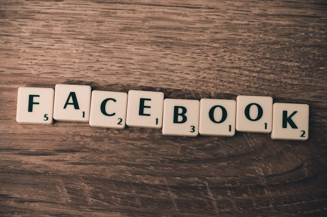 Scrabble tiles spelling Facebook on a wooden background