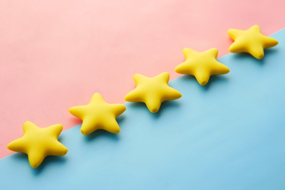 Five yellow stars on colorful background representing online reviews and ratings