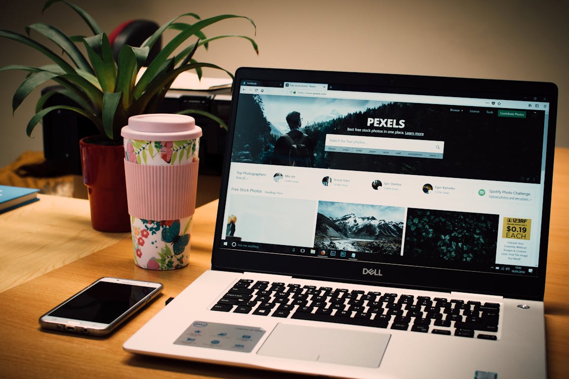 Tidy desk with a laptop displaying a modern website next to a smartphone