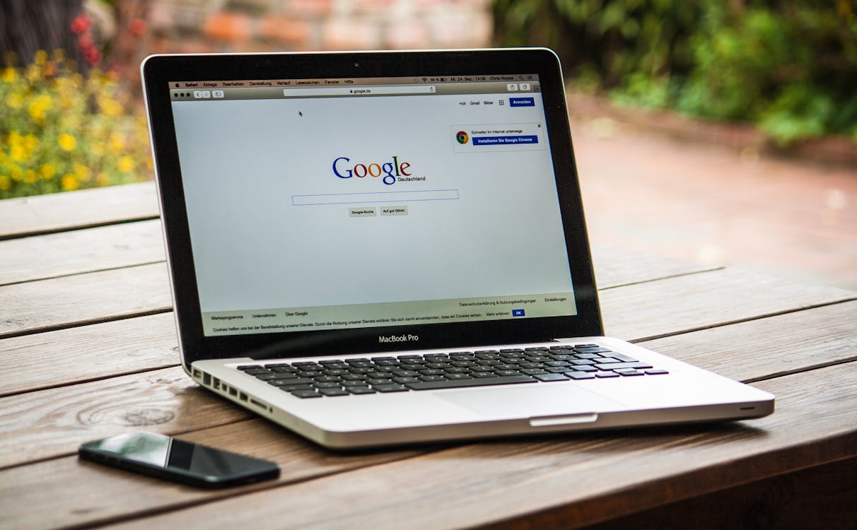 MacBook Pro displaying Google search engine on a wooden table