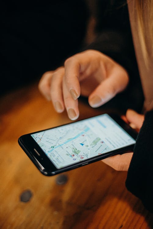 Hand using a smartphone to navigate a map for local business search