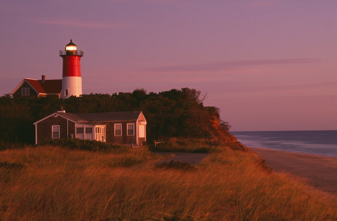 Nauset Lighthouse in Massachusetts surrounded by coastal landscape at sunset
