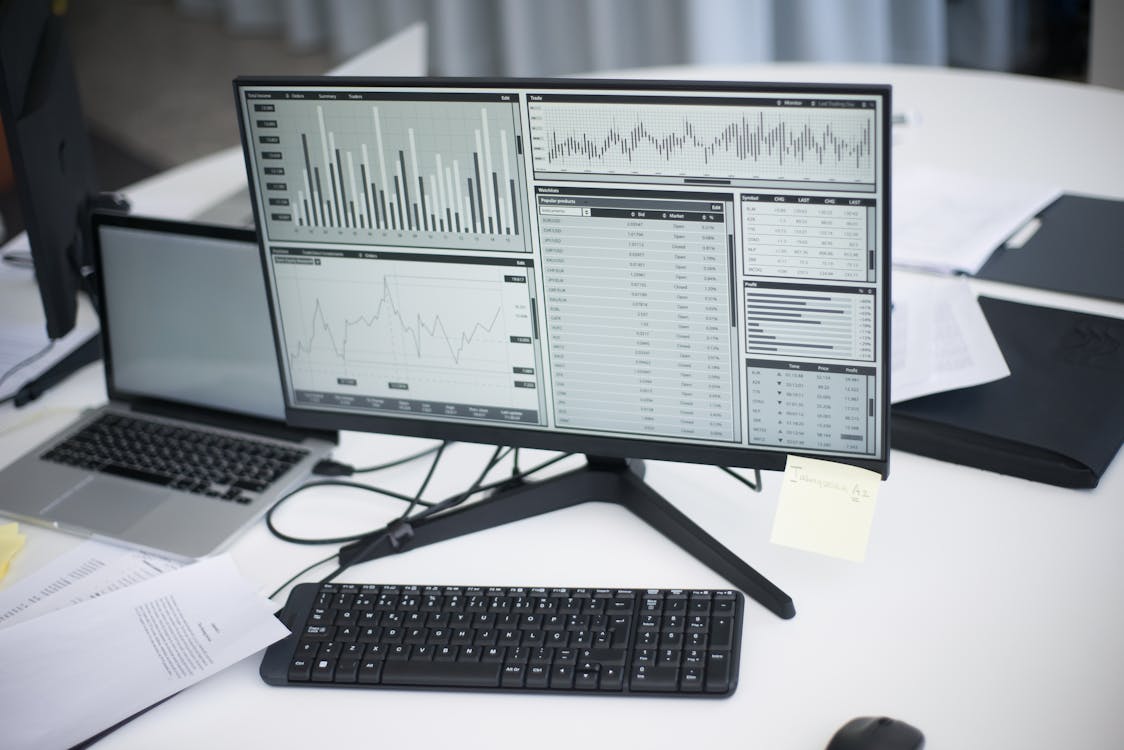 Professional workspace with analytical graphs showing search rankings on a monitor